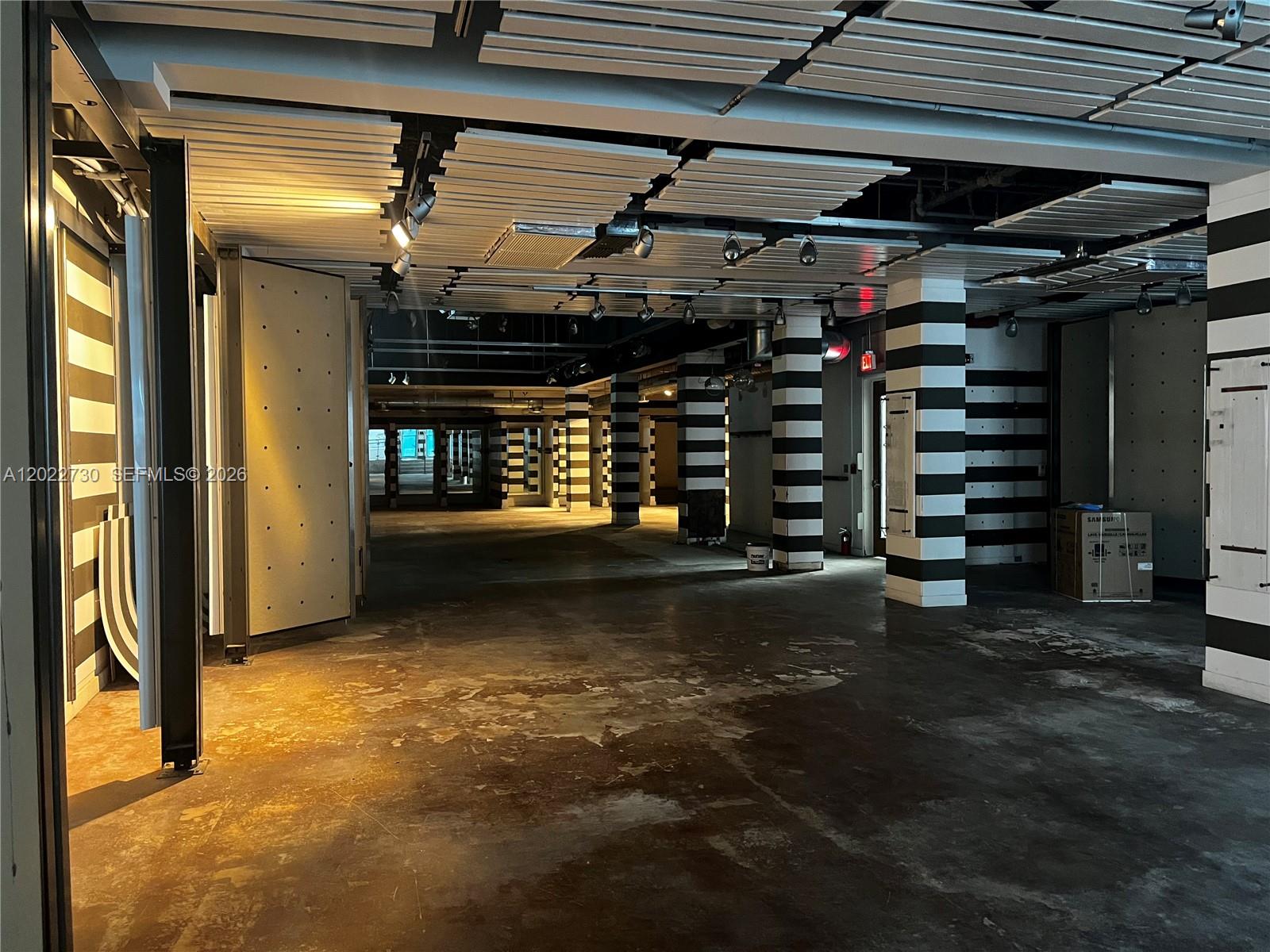 This unfinished commercial space features concrete floors, striped support columns, and exposed ceiling panels — 826 Collins Ave, Miami Beach FL 33139, MIAMI BEACH, FL
