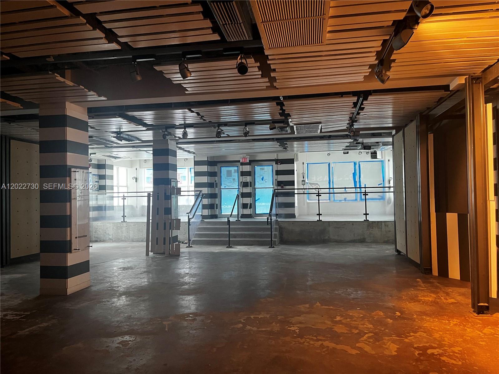 An unfinished commercial space features striped columns, a slatted ceiling, and a raised platform area — 826 Collins Ave, Miami Beach FL 33139, MIAMI BEACH, FL