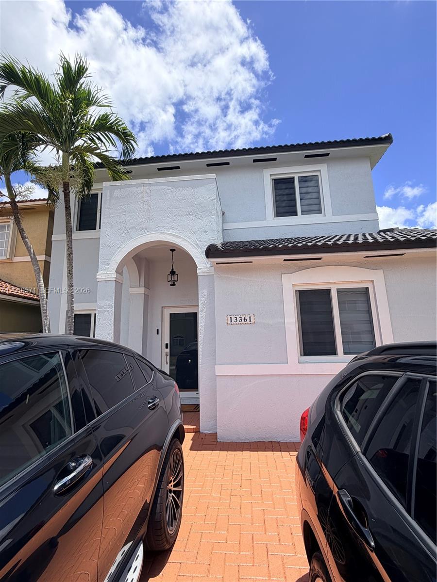 A two-story house exterior features a paved driveway, a palm tree, and a covered entryway — 13361 SW 143rd Ter # 0, Miami FL 33186, MIAMI, FL