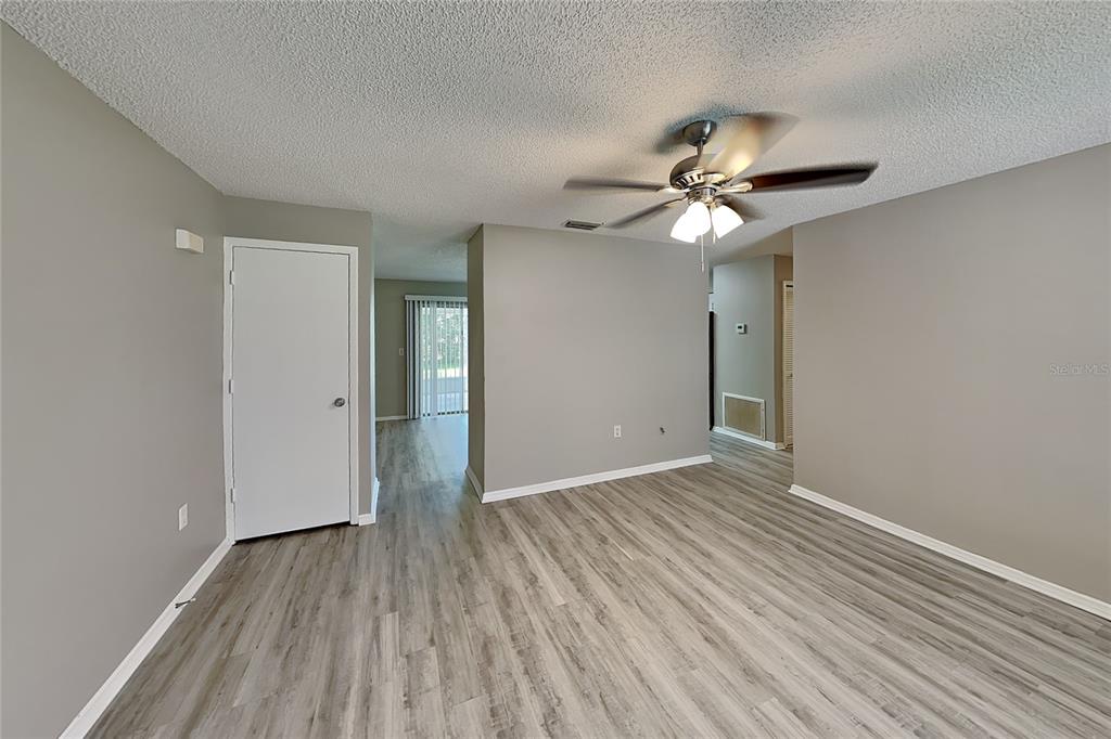 A living room with gray walls, light wood-look flooring, and a ceiling fan — 3352 MERCHANT TERRACE, DELTONA, FL