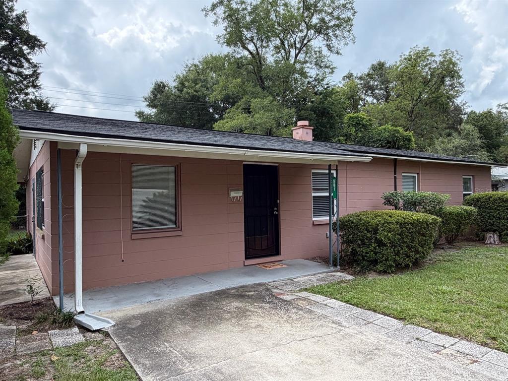 A single-story house with pink exterior walls, a dark roof, and a concrete driveway — 901 NE 23RD STREET, GAINESVILLE, FL