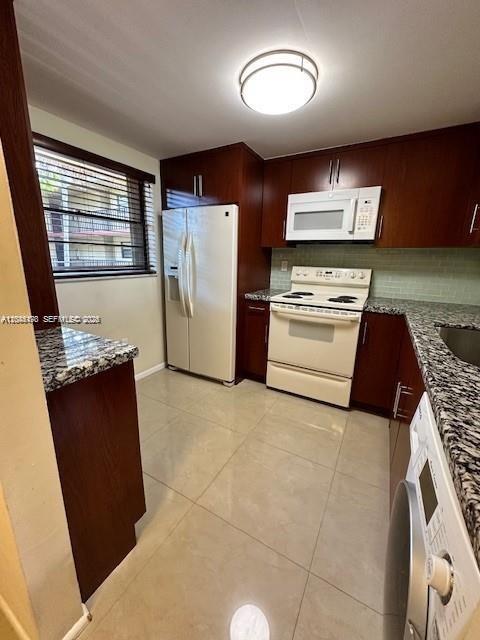 A kitchen features dark wood cabinets, granite countertops, a white stove, and a white dishwasher — 10845 SW 112th Ave # 211, Miami FL 33176, MIAMI, FL