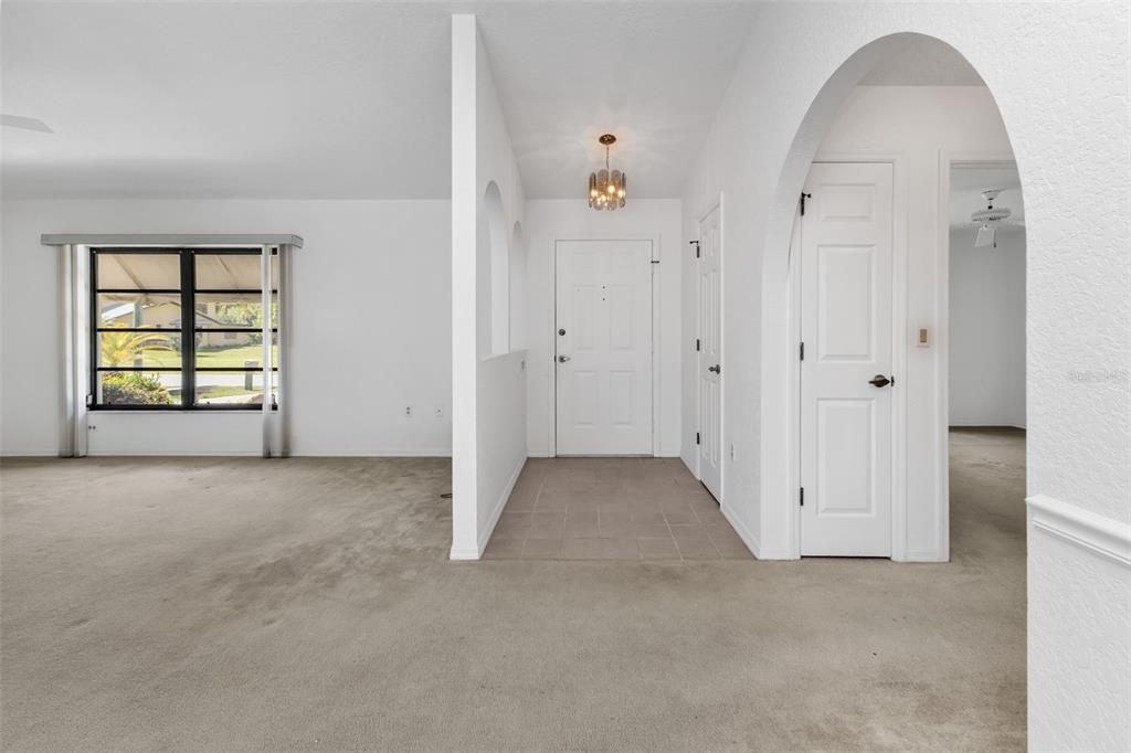 An entryway with tile flooring, a white front door, and an arched doorway to the right — 18250 GRACE AVENUE, PORT CHARLOTTE, FL