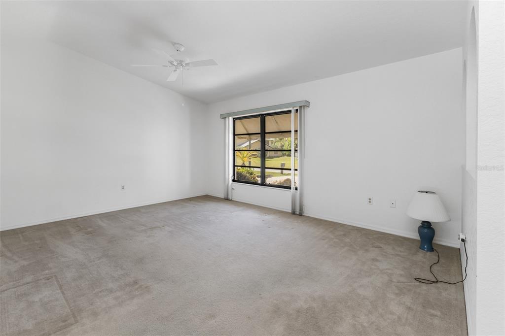 An empty bedroom with white walls, beige carpeting, a ceiling fan, and a single window — 18250 GRACE AVENUE, PORT CHARLOTTE, FL