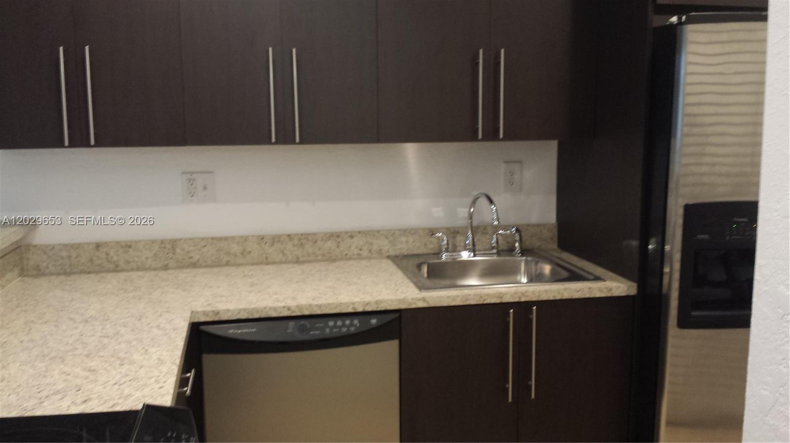 A kitchen features dark wood cabinets, a speckled countertop, a stainless steel sink, and appliances — 7473 SW 82nd St # A313, Miami FL 33143, MIAMI, FL