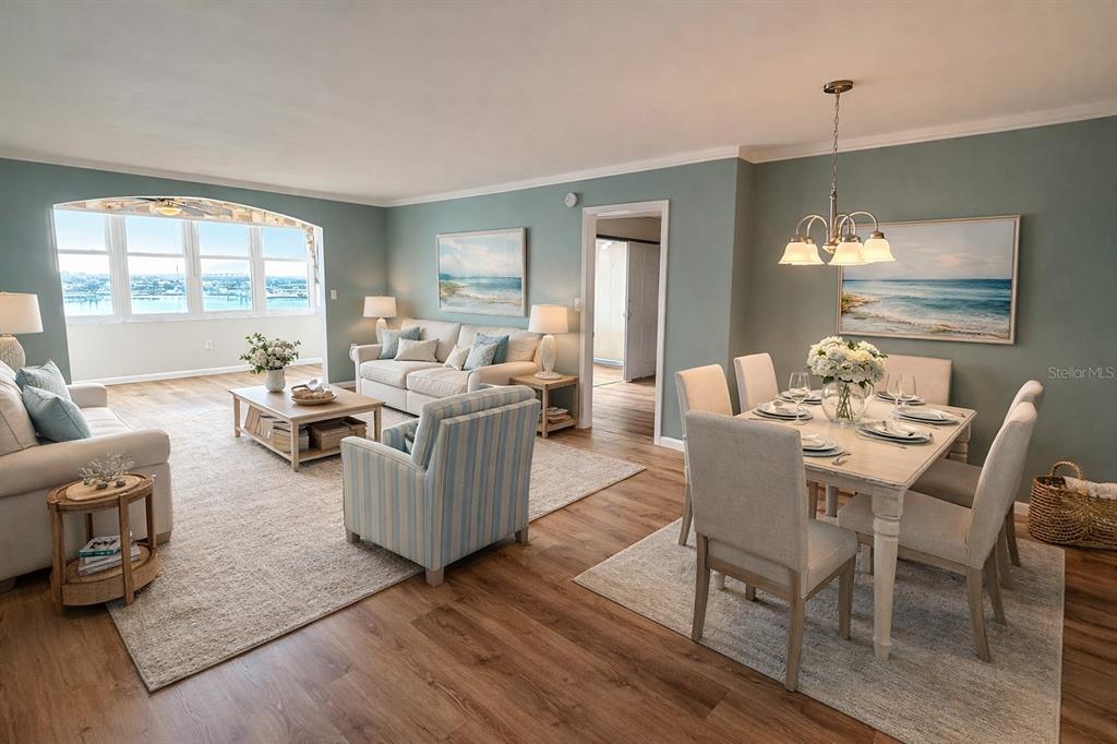 A living and dining room with light blue walls, wood-look flooring, and a waterfront view — 5130 BRITTANY DRIVE S UNIT 807, ST PETERSBURG, FL