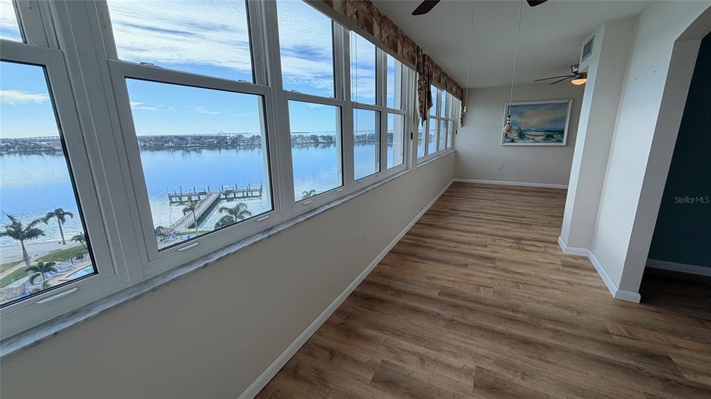 A sunroom with wood-look flooring and large windows overlooking a waterfront view — 5130 BRITTANY DRIVE S UNIT 807, ST PETERSBURG, FL