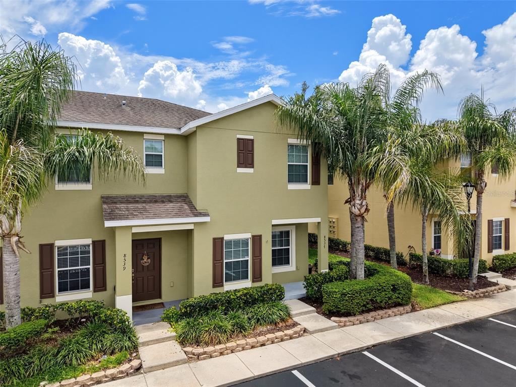 A bedroom features a bed, a leather bench, an armchair, and a ceiling fan — 8537 BRUSHLEAF WAY, TAMPA, FL