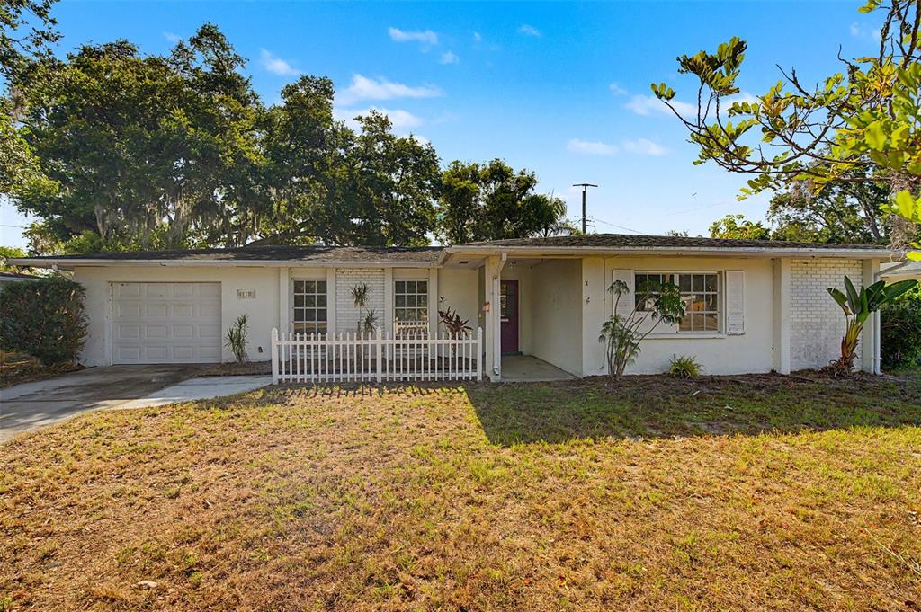 A single-story house with a white exterior, a one-car garage, and a small front fence — 4113 PRUDENCE DRIVE, SARASOTA, FL