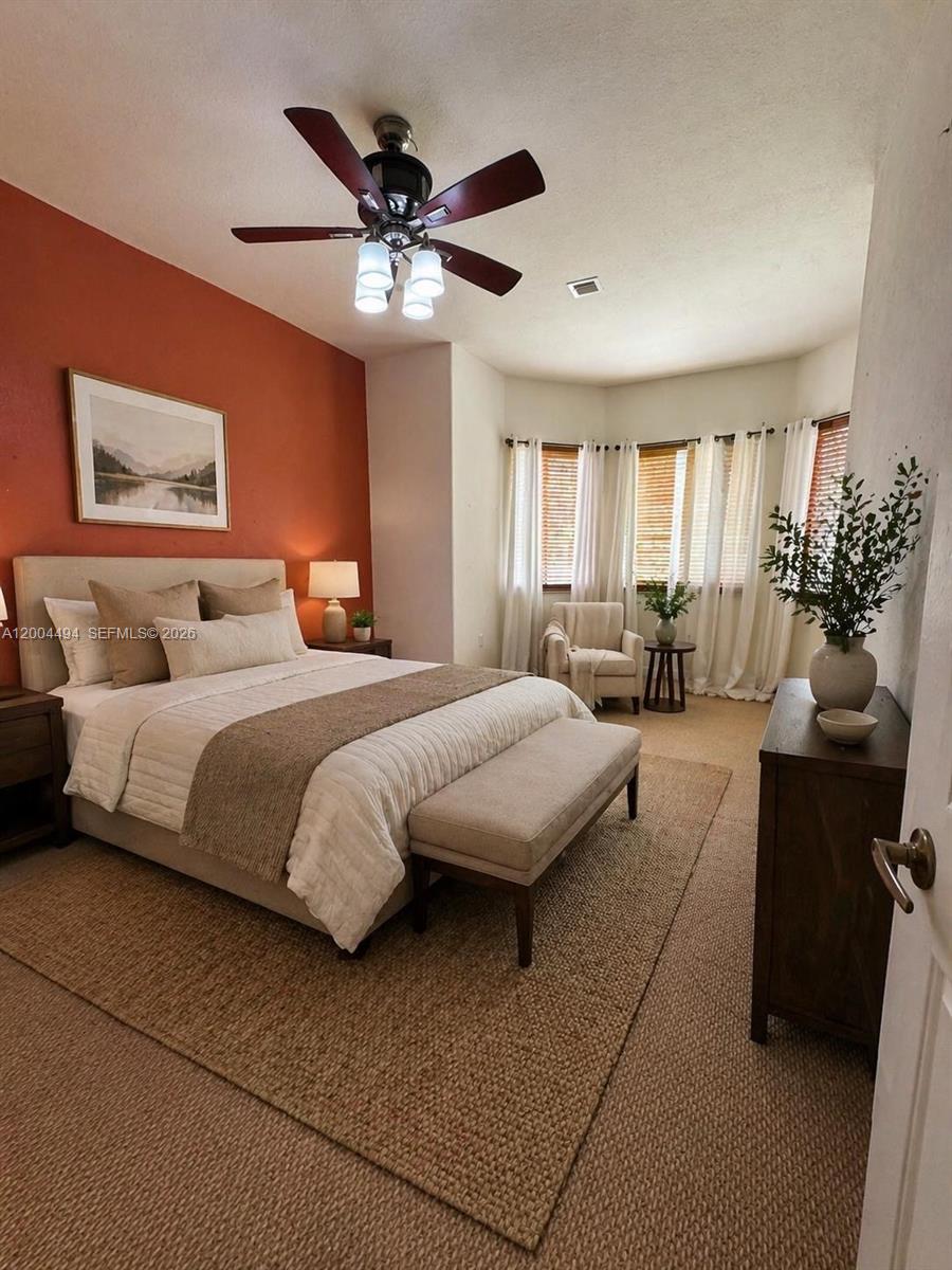A bedroom features a terracotta accent wall, a queen bed, and a bay window — 7441 SW 187th St, Cutler Bay FL 33157, CUTLER BAY, FL