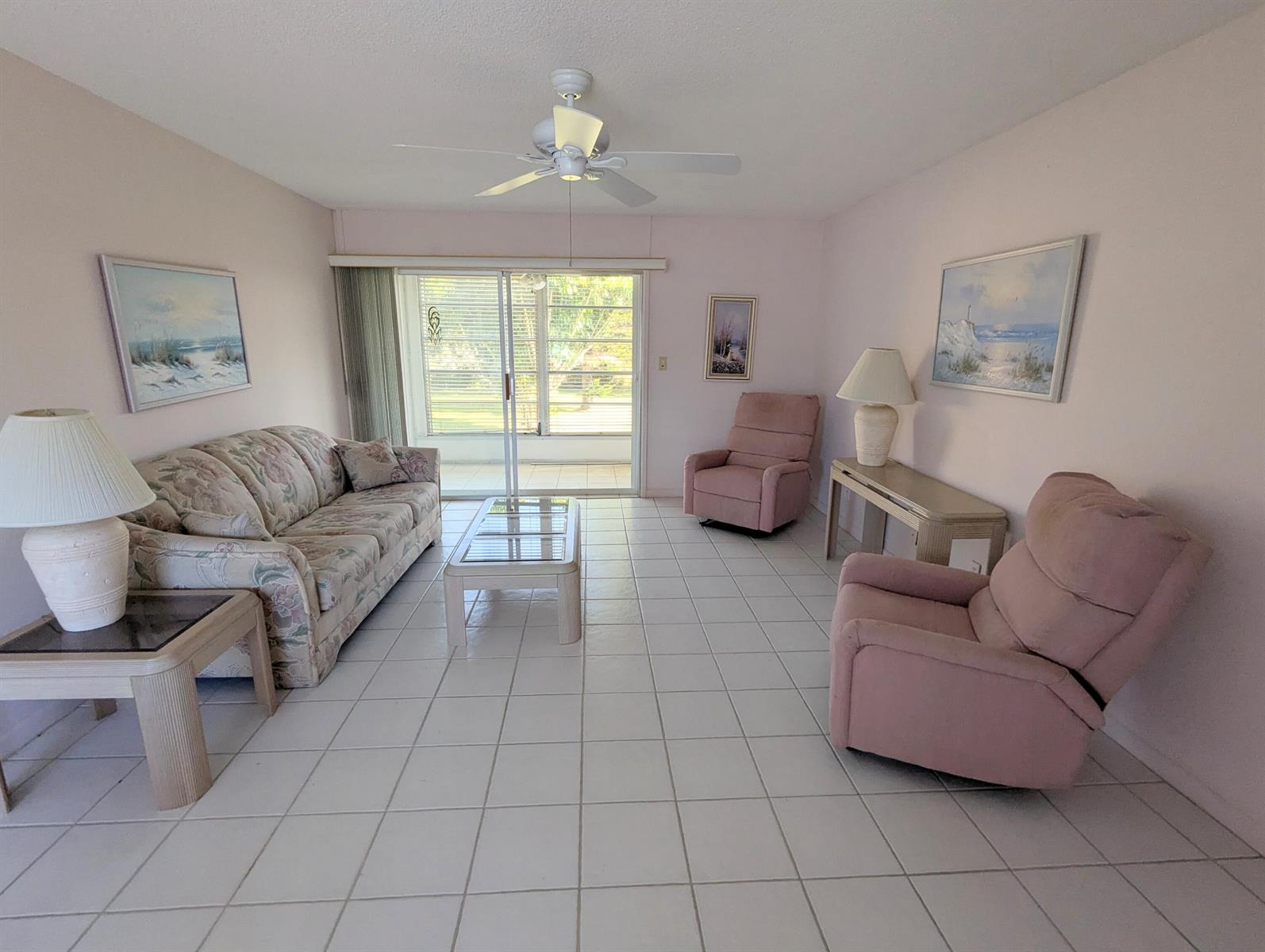 A living room features a floral sofa, two pink recliners, tile flooring, and a ceiling fan — 2 Golfs Edge # D, West Palm Beach FL 33417, WEST PALM BEACH, FL
