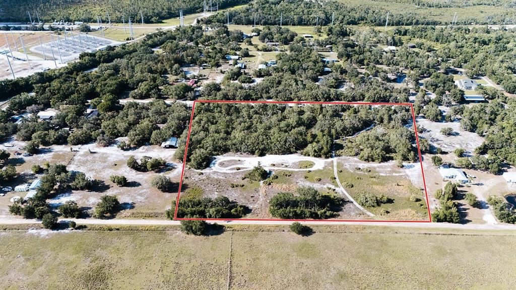An aerial view shows a rectangular plot of land outlined in red with scattered trees — MILES BREEZE AVENUE, RIVERVIEW, FL