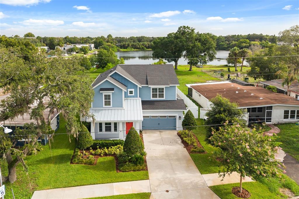 An aerial view of a two-story blue house with a garage and a lake behind — 4401 PARK LAKE STREET, ORLANDO, FL