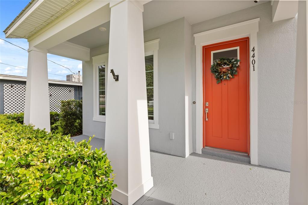 A bright orange front door with a wreath sits on a covered porch with columns — 4401 PARK LAKE STREET, ORLANDO, FL