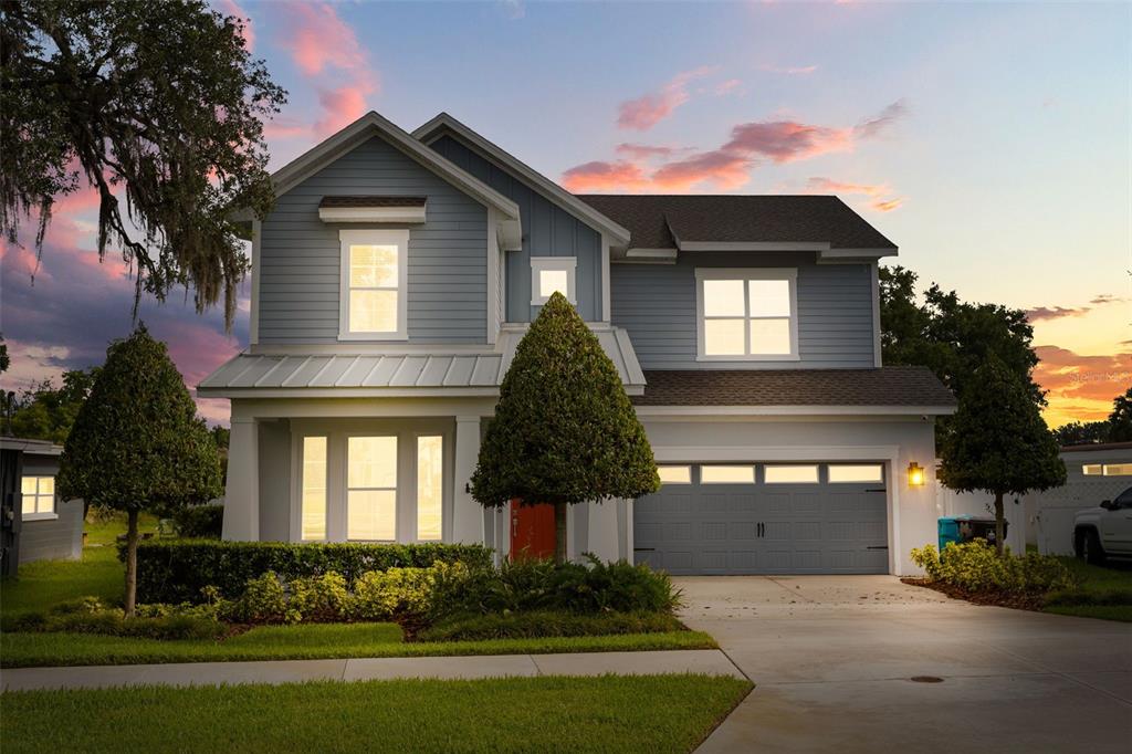 A two-story blue house with a front porch, a two-car garage, and a landscaped yard — 4401 PARK LAKE STREET, ORLANDO, FL