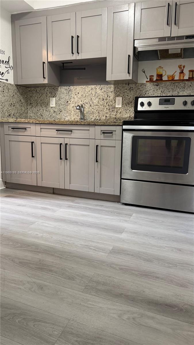 A kitchen features light gray cabinets, granite countertops, and stainless steel appliances — 2238 NW 5th St # 1, Miami FL 33125, MIAMI, FL