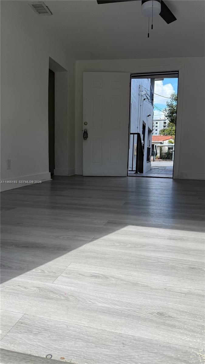 A room with light-colored wood-look flooring leads to an open exterior doorway — 2238 NW 5th St # 1, Miami FL 33125, MIAMI, FL