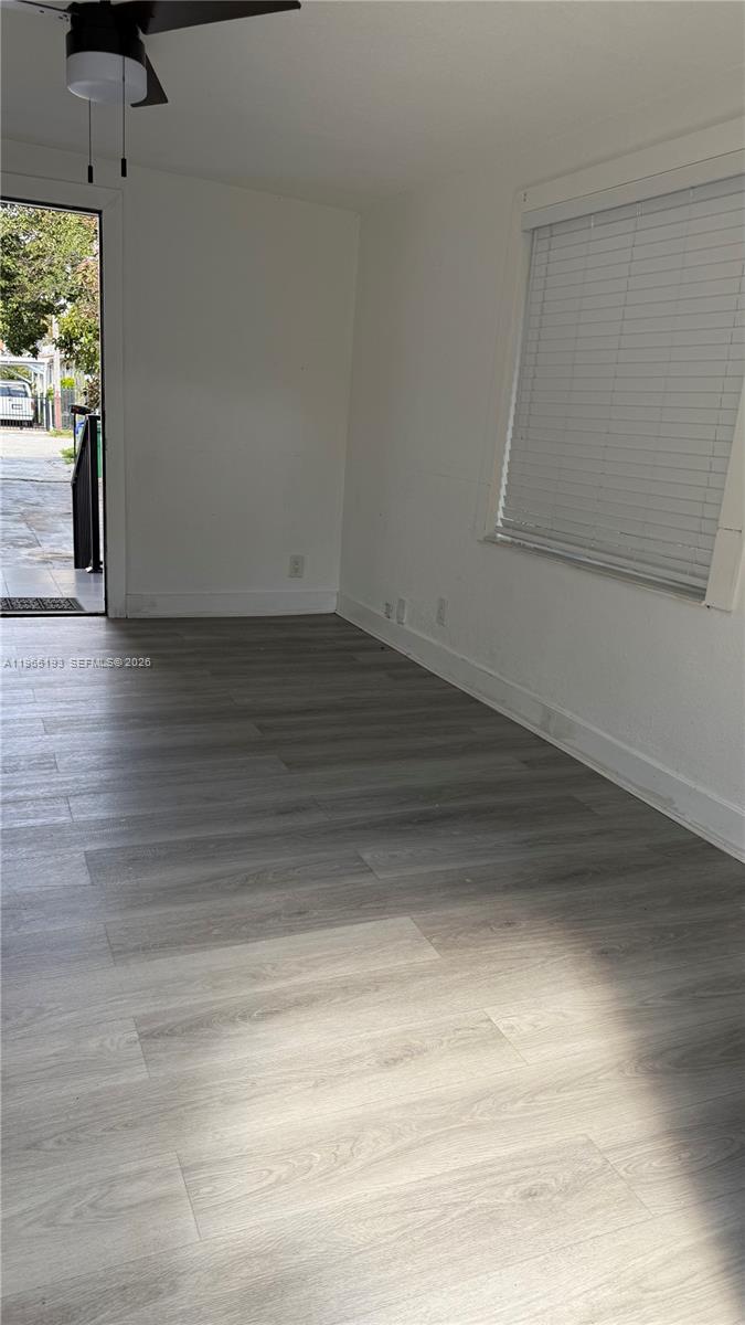 An empty room features light gray wood-look flooring, white walls, a ceiling fan, and a window — 2238 NW 5th St # 1, Miami FL 33125, MIAMI, FL