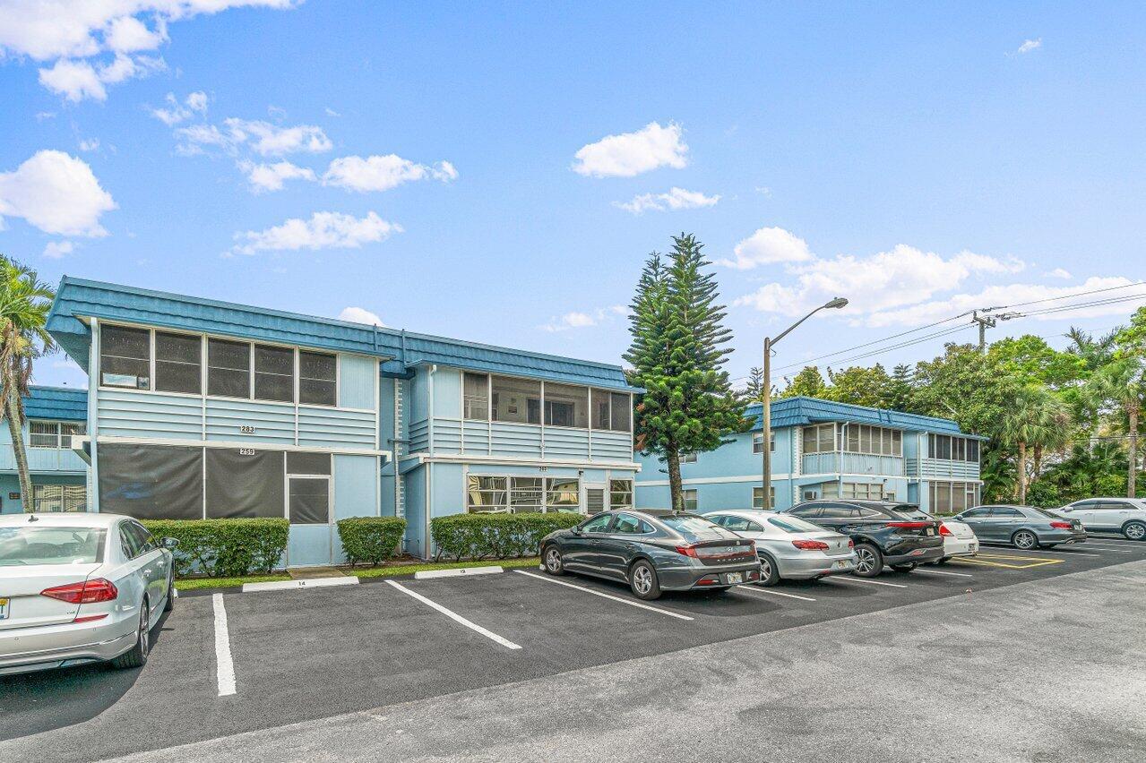 A two-story blue apartment building with a parking lot in front — 260 Brittany F, Delray Beach FL 33446, DELRAY BEACH, FL