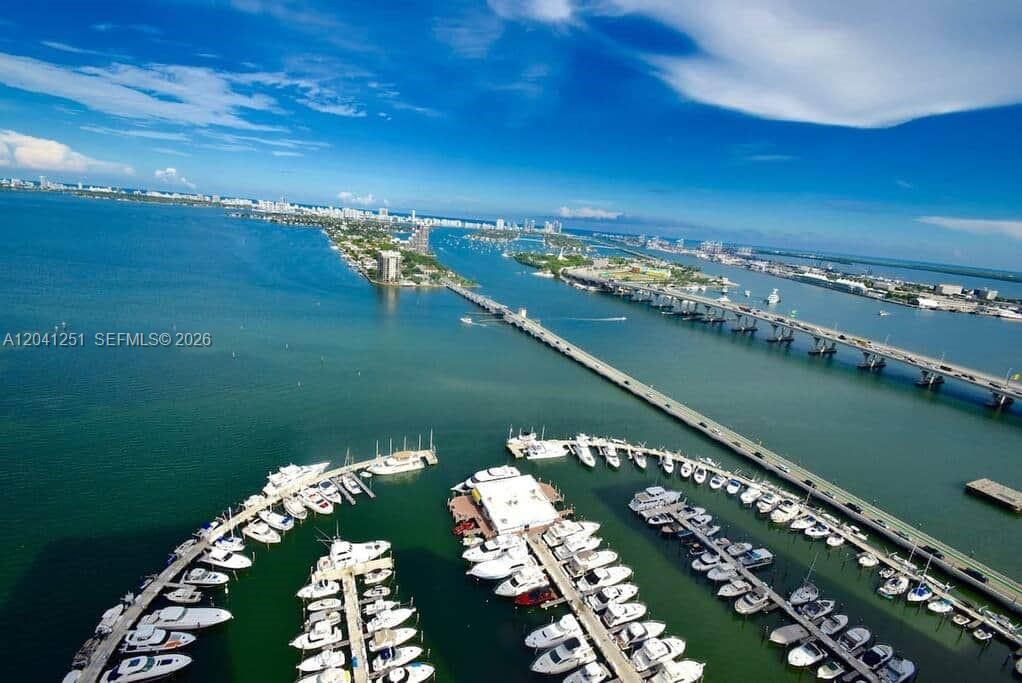An aerial view of a marina with numerous boats docked near a long bridge — 1717 N Bayshore Dr # 3931, Miami FL 33132, MIAMI, FL