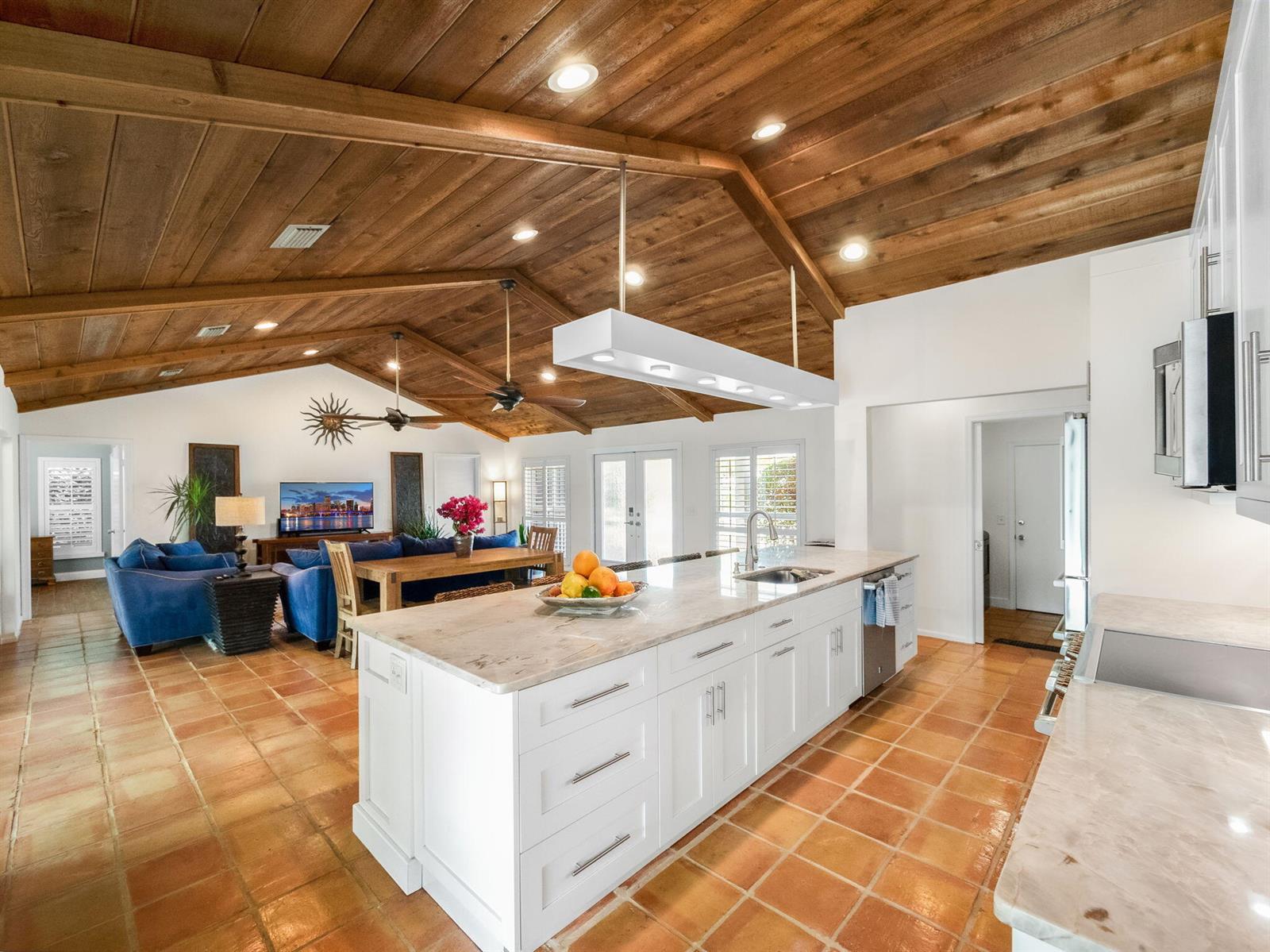 A kitchen with a large white island and terracotta tile floors under a wood-paneled ceiling — 52 Birch Place, Tequesta FL 33469, TEQUESTA, FL