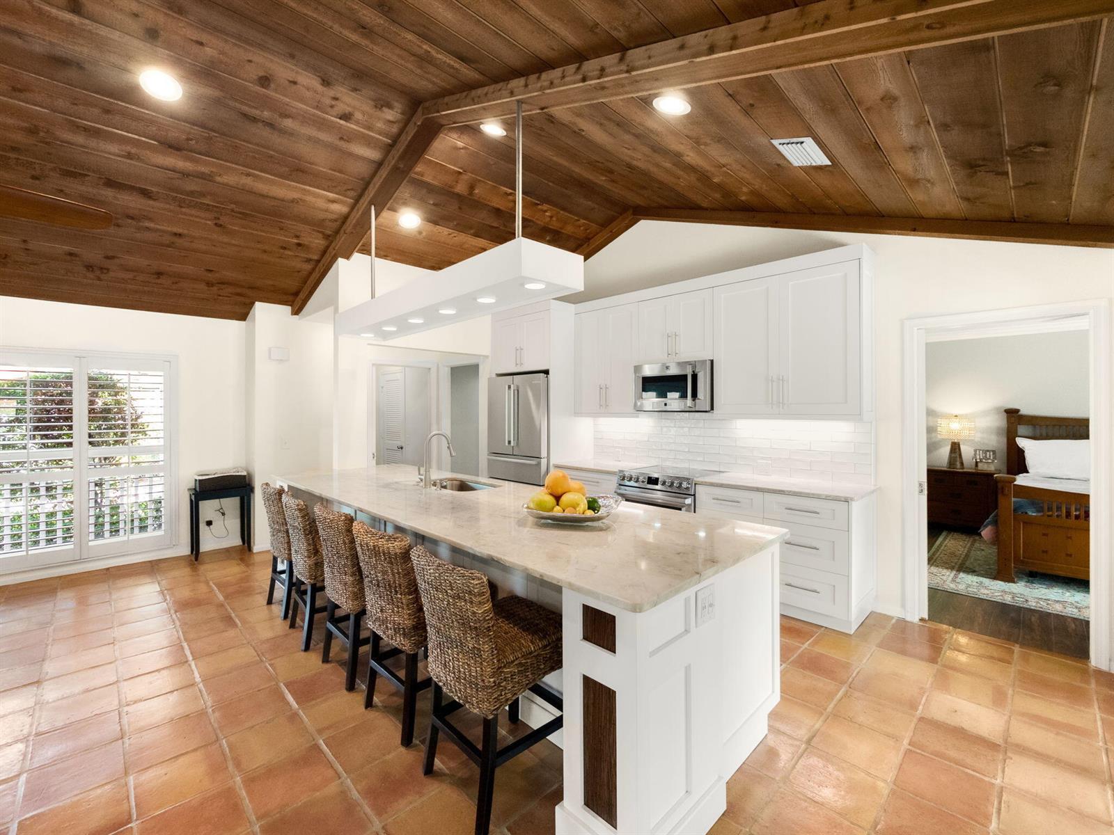 A kitchen with a large island, white cabinets, and a vaulted wood-paneled ceiling — 52 Birch Place, Tequesta FL 33469, TEQUESTA, FL