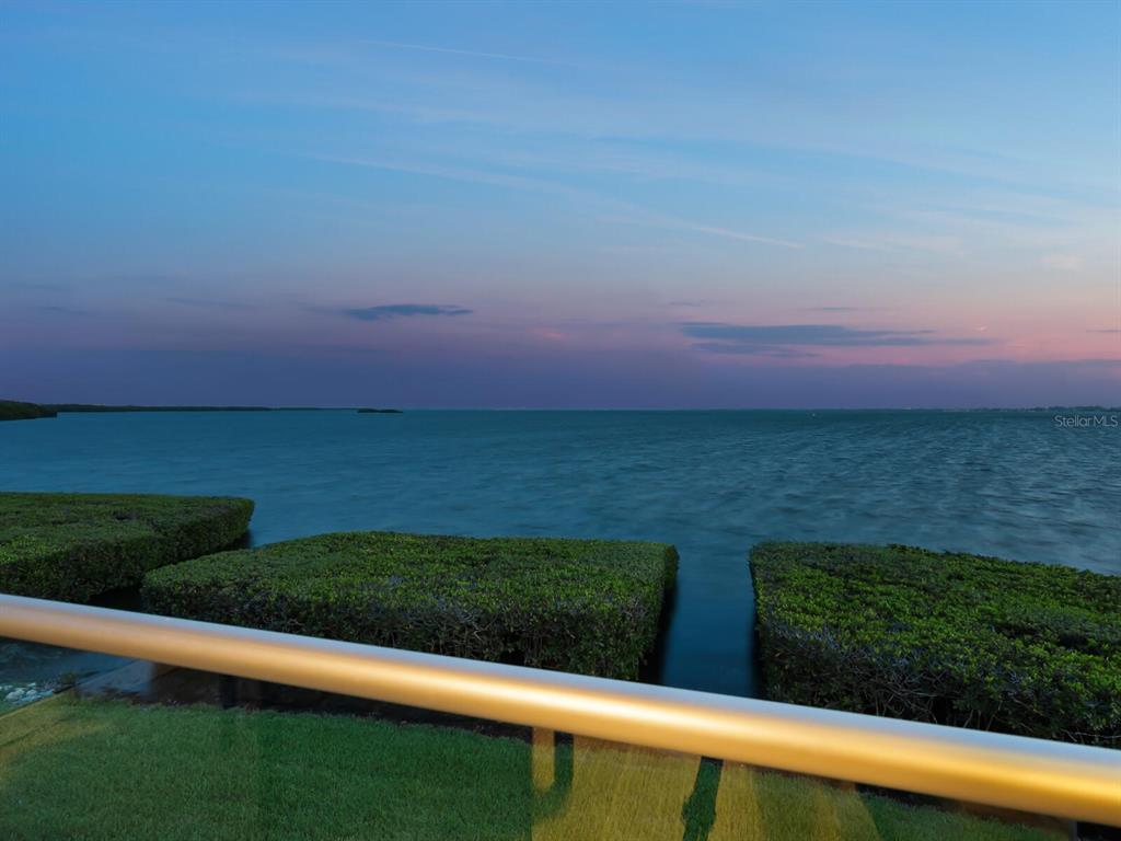 A view of the ocean at sunset from a balcony with a metal railing — 26 TIDY ISLAND BOULEVARD, BRADENTON, FL