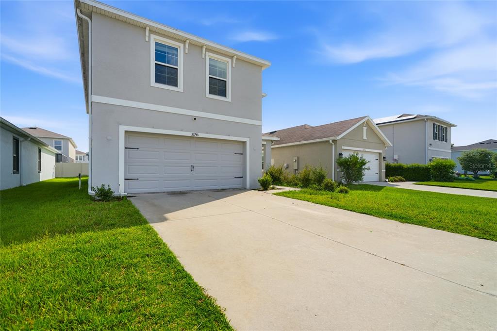 A two-story house with a light gray exterior and a two-car garage — 32745 PEZ LANDING LANE, WESLEY CHAPEL, FL