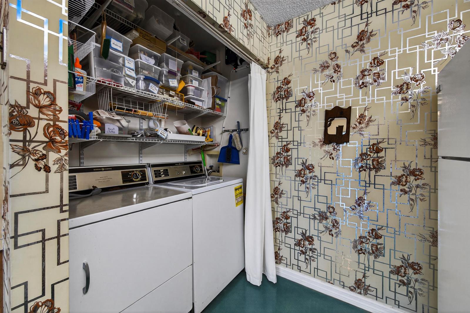 A laundry room features a washer and dryer, wire shelving, and vintage floral geometric wallpaper — 14236 Campanelli Drive, Delray Beach FL 33484, DELRAY BEACH, FL