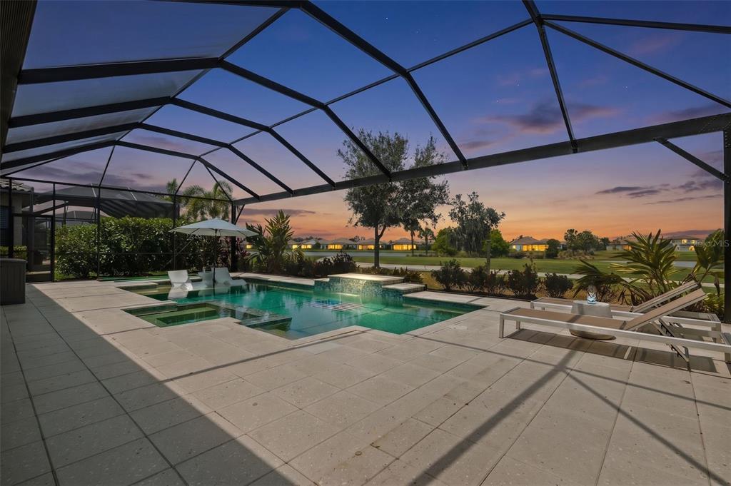 A screened-in pool patio features a swimming pool, spa, lounge chairs, and golf course views — 14817 MONTELLO WAY, BRADENTON, FL