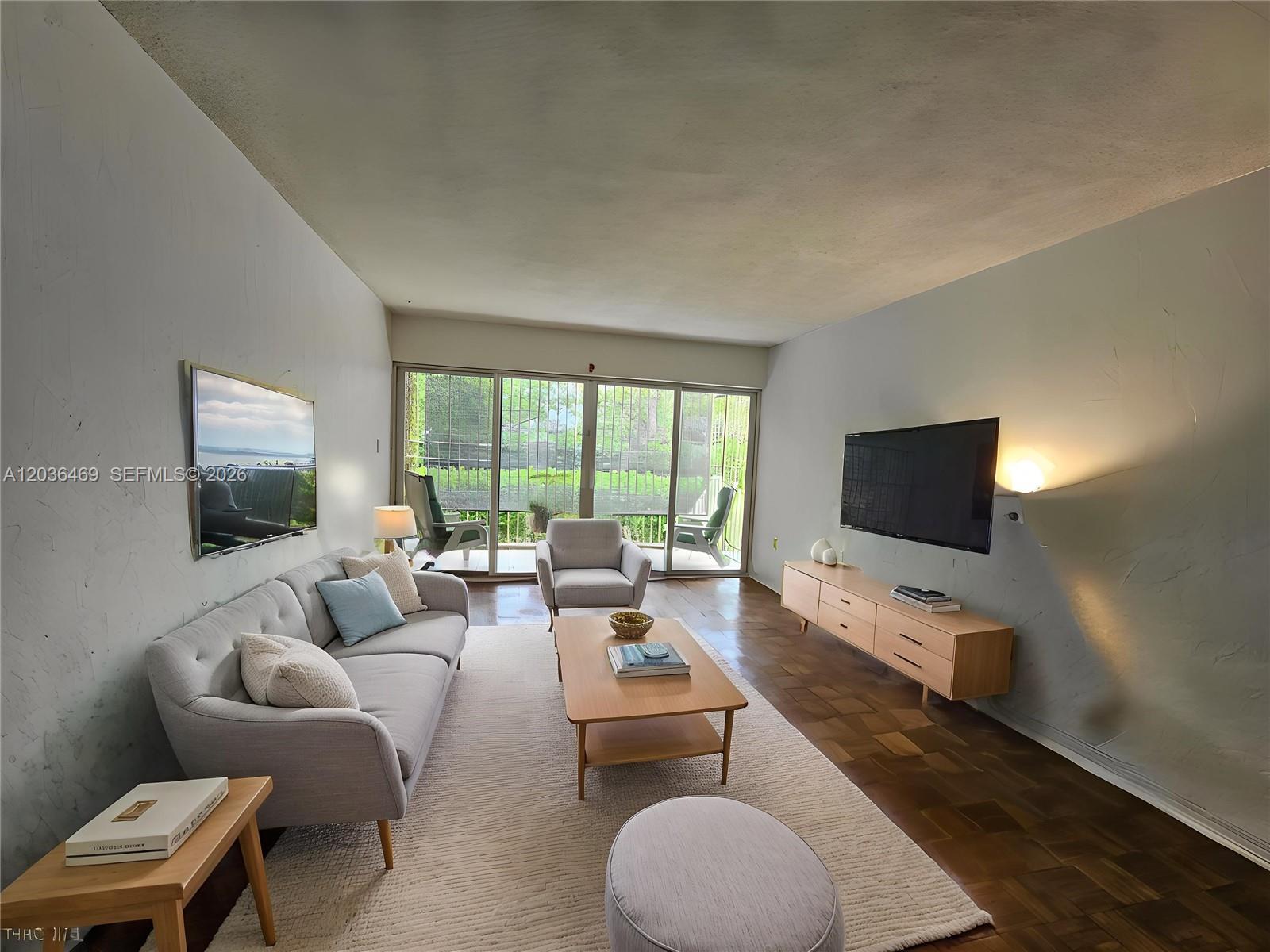 A living room features a light gray sofa, wooden coffee table, and a wall-mounted television — 520 NE 38th St # 12, Miami FL 33137, MIAMI, FL