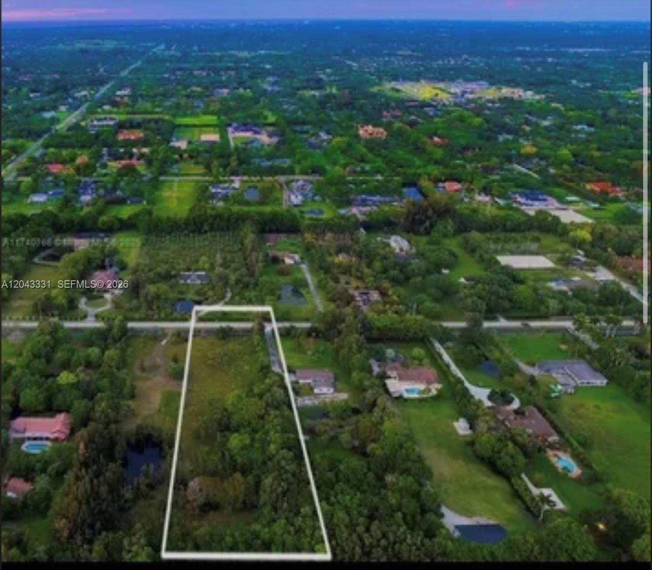An aerial view shows a rectangular, tree-covered vacant lot outlined in white within a neighborhood — 14010 Mustang Trl, Southwest Ranches FL 33330, SOUTHWEST RANCHES, FL