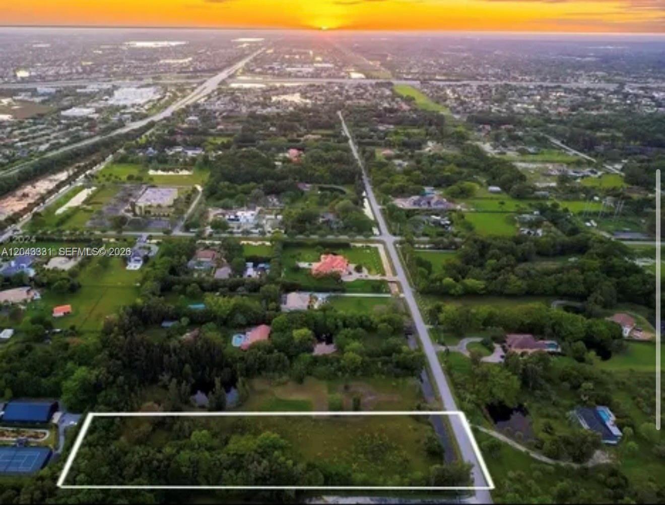 An aerial view shows a rectangular vacant lot outlined in white next to a paved road — 14010 Mustang Trl, Southwest Ranches FL 33330, SOUTHWEST RANCHES, FL