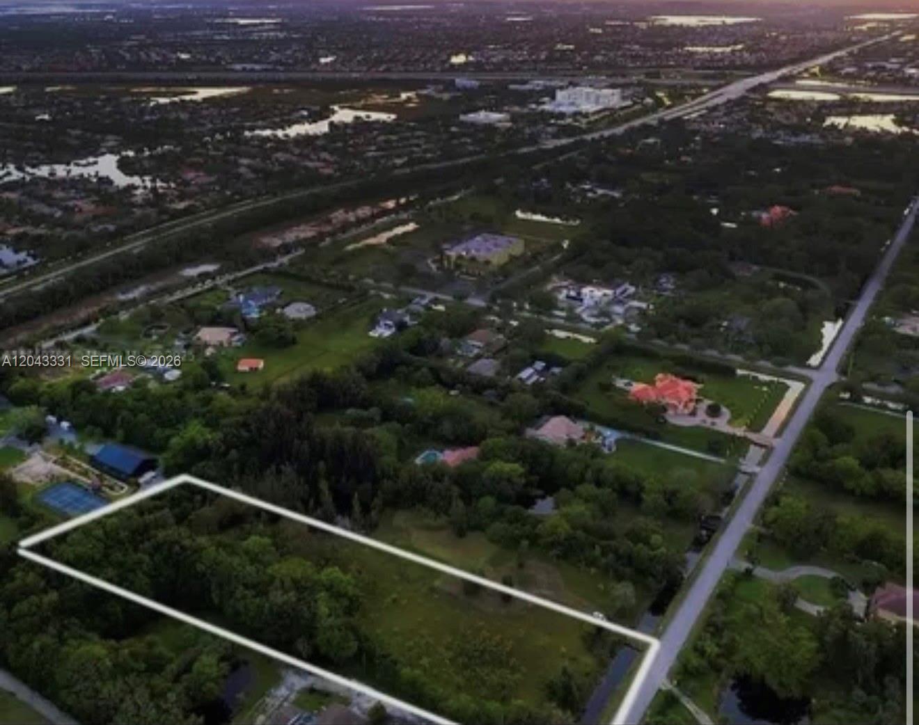 An aerial view shows a rectangular, tree-covered vacant lot outlined in white near a road — 14010 Mustang Trl, Southwest Ranches FL 33330, SOUTHWEST RANCHES, FL