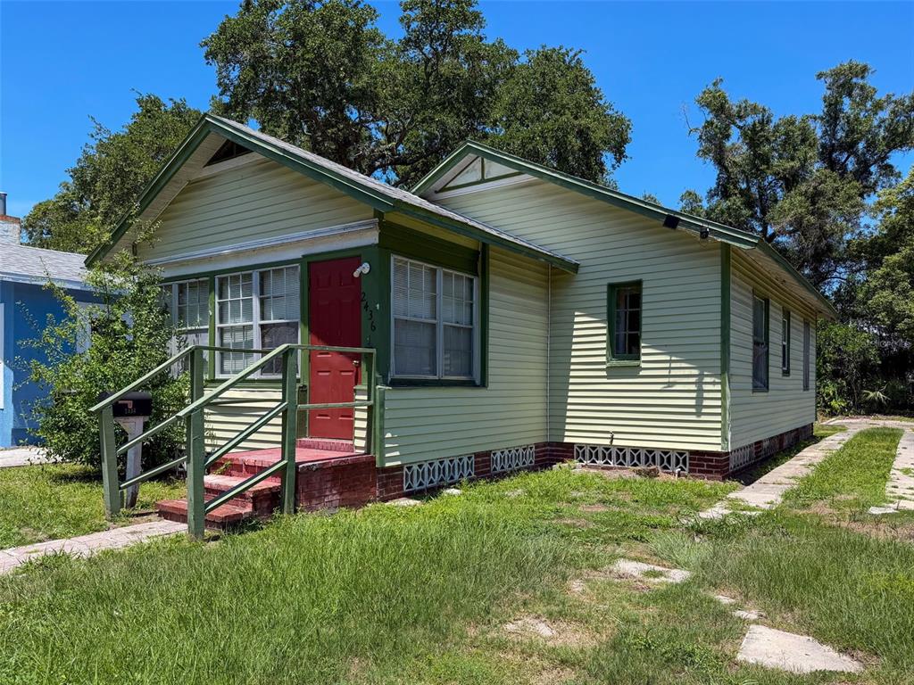 A light green, single-story house with a red front door and a brick porch — 2436 10TH STREET S, ST PETERSBURG, FL