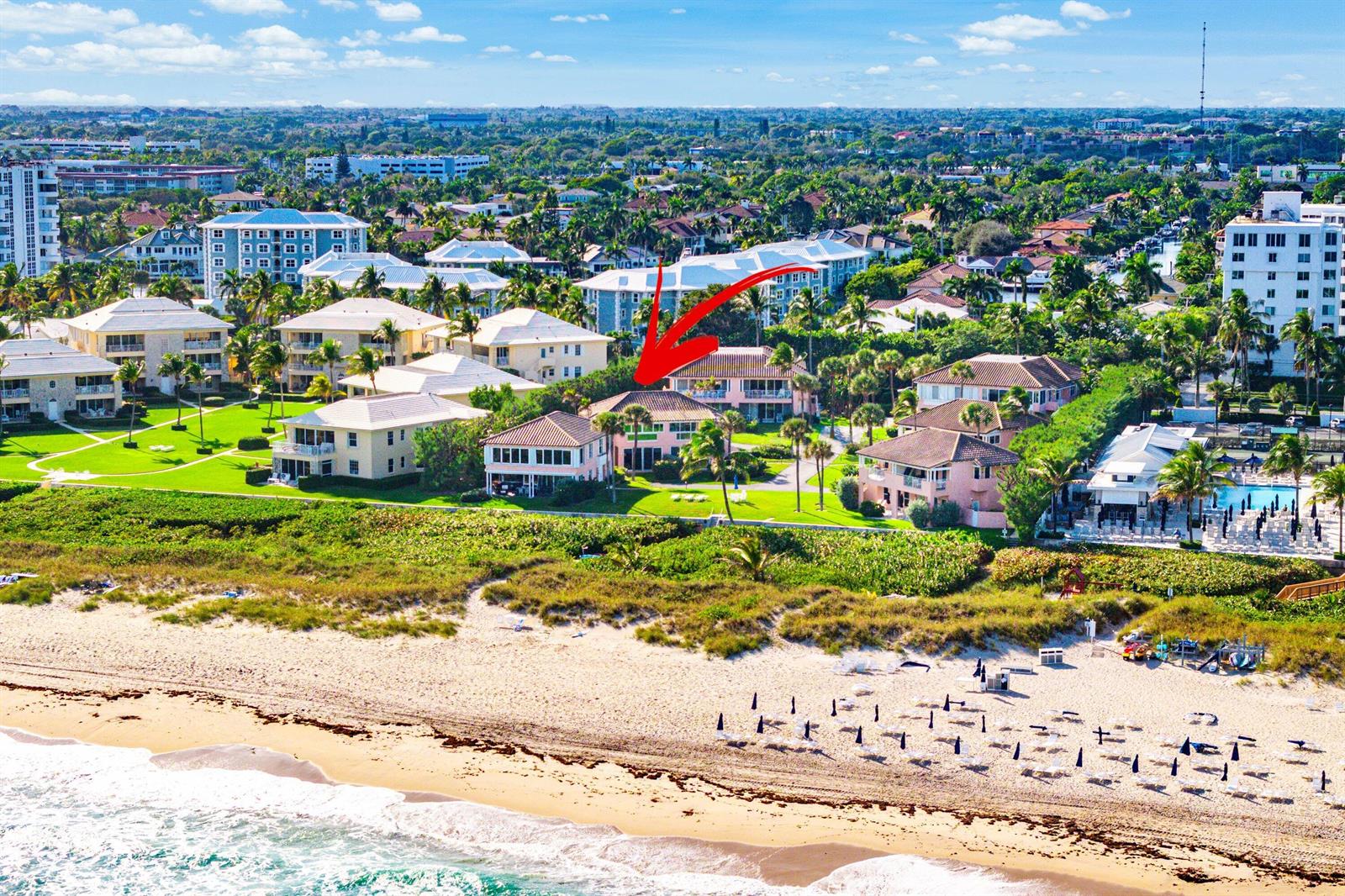 An aerial view shows a pink beachfront residential complex surrounded by palm trees and landscaping — 2075 S Ocean Boulevard # 3d, Delray Beach FL 33483, DELRAY BEACH, FL
