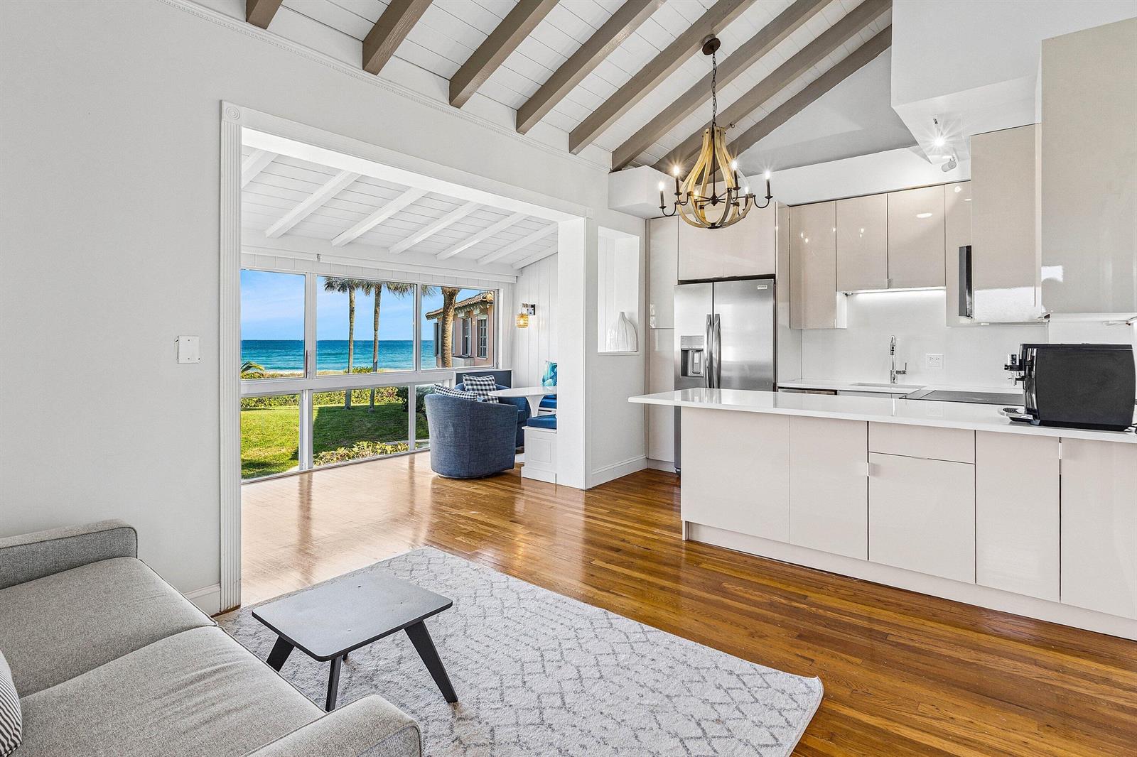 A modern kitchen and living area feature wood floors, vaulted ceilings, and ocean views — 2075 S Ocean Boulevard # 3d, Delray Beach FL 33483, DELRAY BEACH, FL