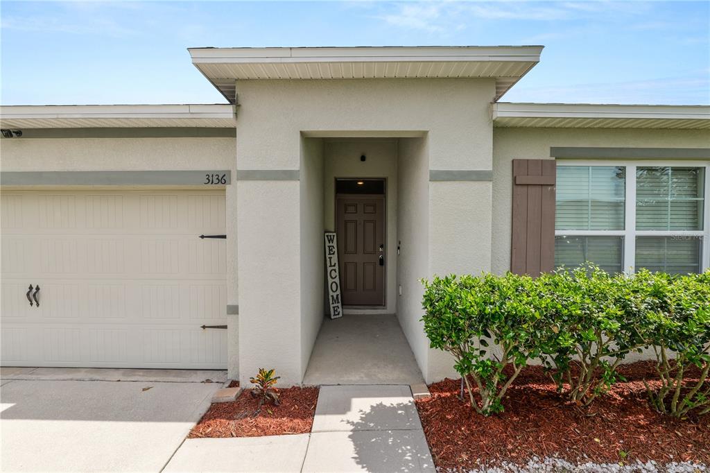 The exterior of a house features a garage, a recessed entryway, and a front window — 3136 COUNTRY CLUB CIRCLE, WINTER HAVEN, FL