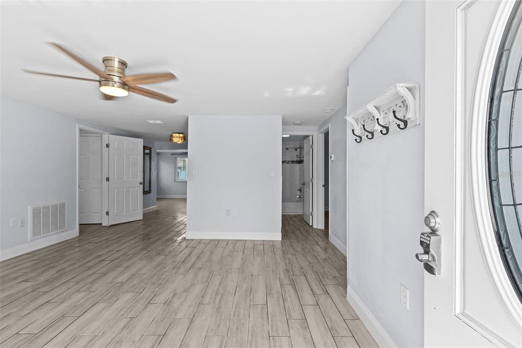An interior view of a room with light wood-look tile flooring and a ceiling fan — 13916 SOMMERS AVENUE, HUDSON, FL