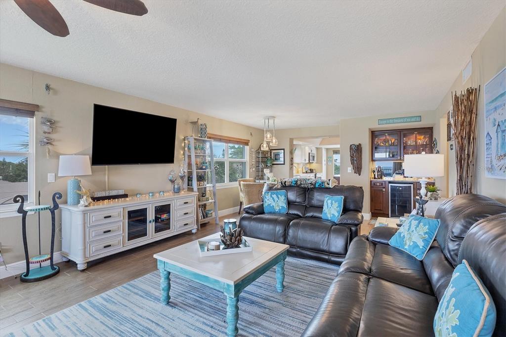 A living room features a large television, dark leather sofas, a coffee table, and a bar — 4325 GULF OF MEXICO DRIVE UNIT 408, LONGBOAT KEY, FL