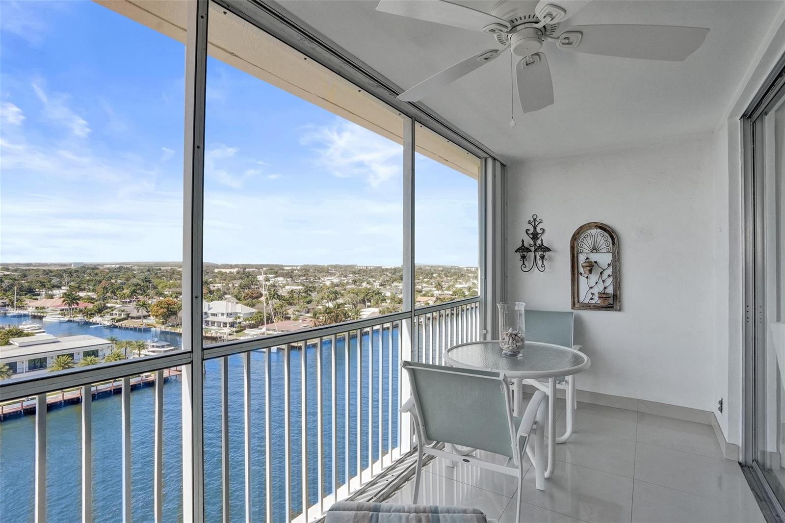 A screened-in balcony features tile flooring, a ceiling fan, and a view of the water — 303 N Riverside Drive, Pompano Beach FL 33062, POMPANO BEACH, FL