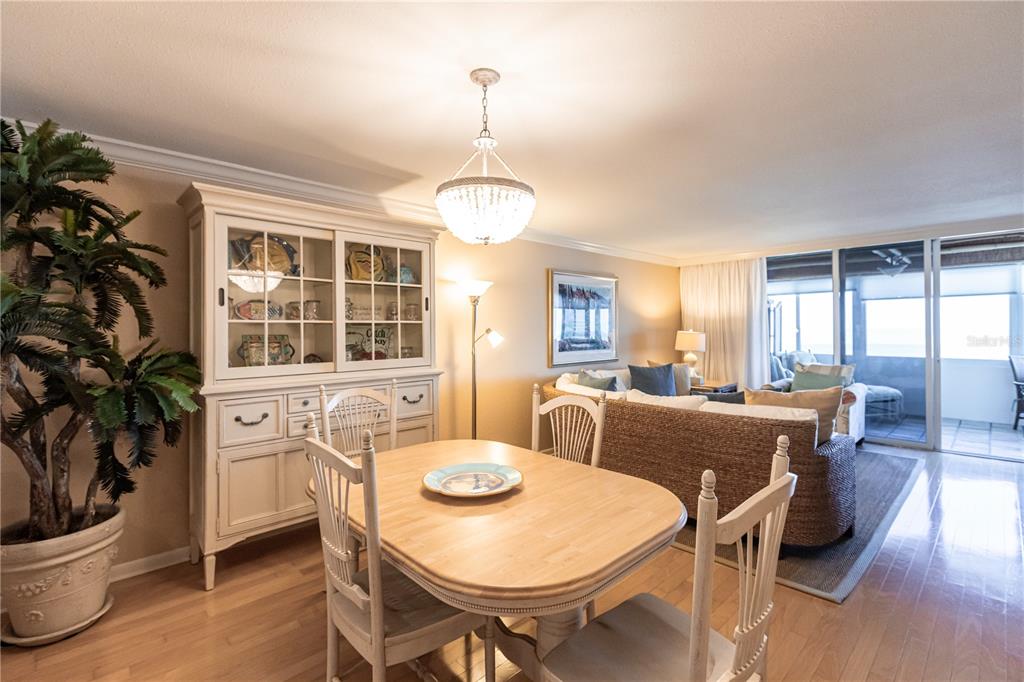 A dining area with a wooden table and hutch opens into a living room — 1055 W PEPPERTREE DRIVE UNIT 703AA, SARASOTA, FL