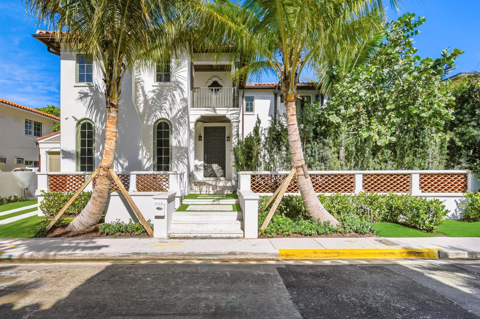 A two-story white stucco house features arched windows, a balcony, and palm trees out front — 259 Oleander Avenue, Palm Beach FL 33480, PALM BEACH, FL