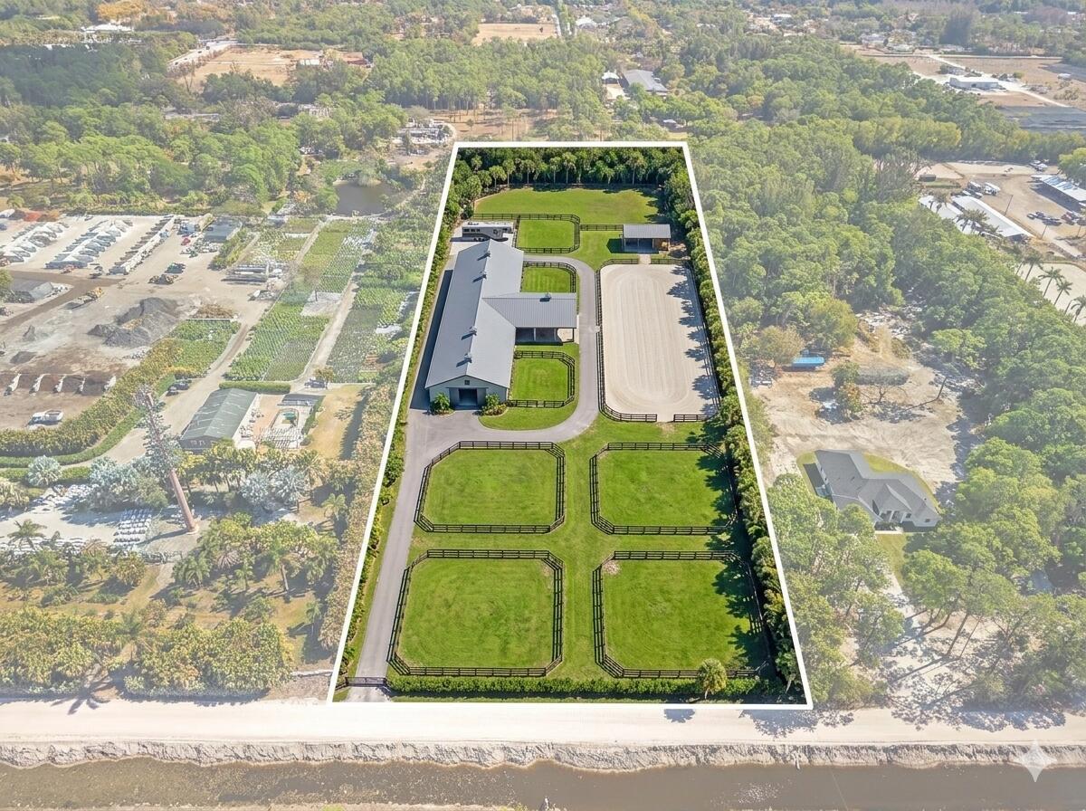 An aerial view shows a rectangular equestrian property with a barn, paddocks, and riding arena — 1814 A Road, FL 33470, FL