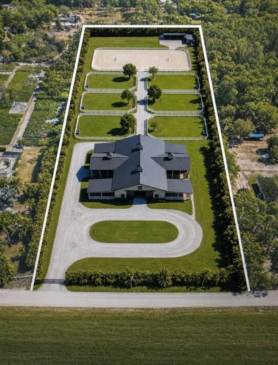 An aerial view of a horse farm featuring a central barn, paddocks, and a riding arena — 1814 A Road, FL 33470, FL