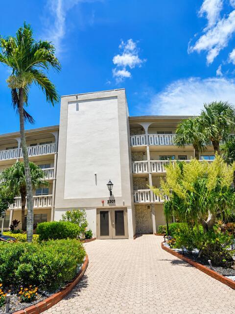 A multi-story apartment building with a paved walkway leading to a central entrance — 3301 Aruba Way # K2, Coconut Creek FL 33066, COCONUT CREEK, FL