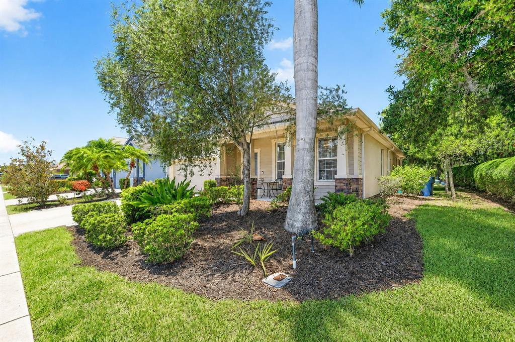 A single-story house with a tan exterior, stone accents, and a landscaped front yard — 5512 MANG PLACE, SARASOTA, FL
