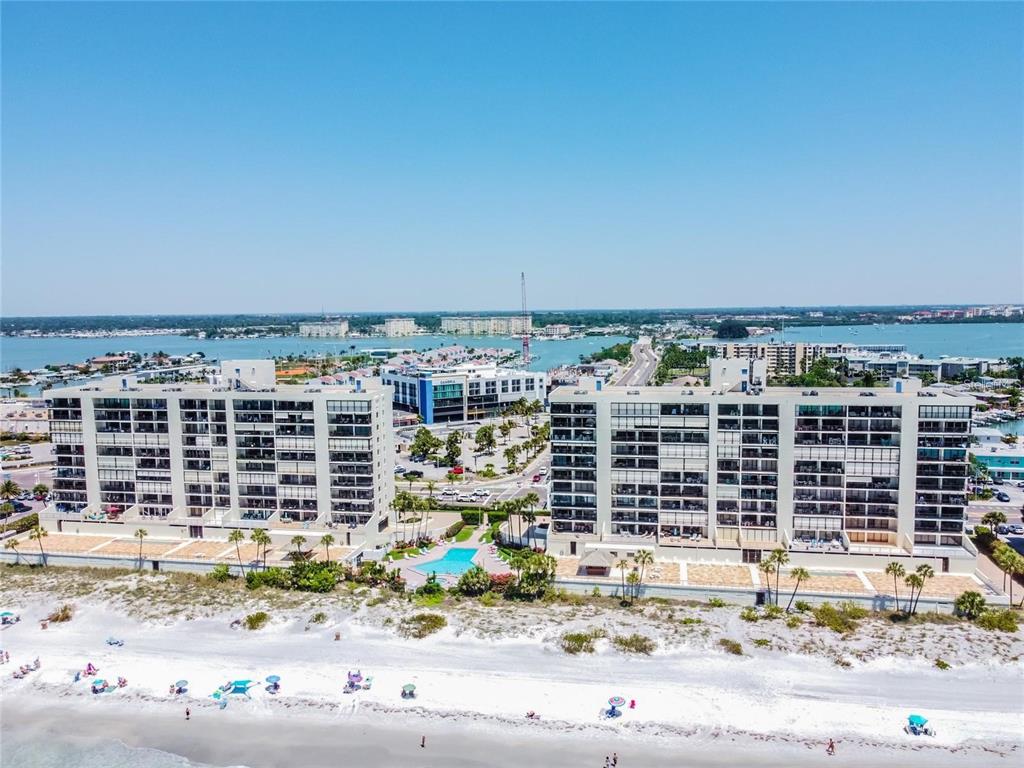 An aerial view shows two large beachfront apartment buildings with a pool between them — 15000 GULF BOULEVARD UNIT 1108, MADEIRA BEACH, FL