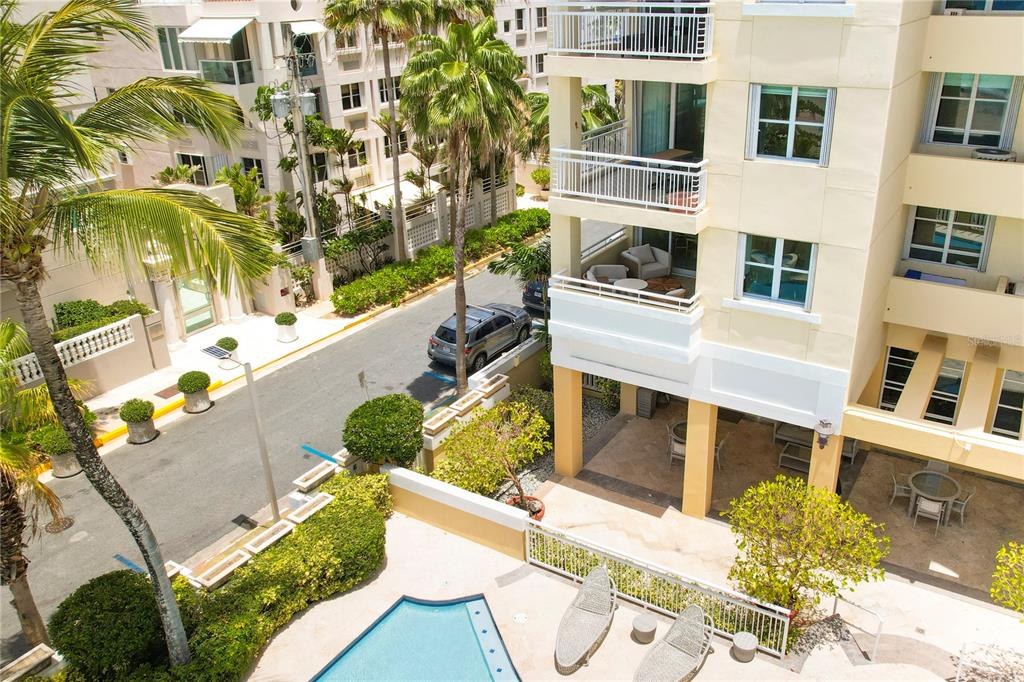 An aerial view of a tall, light-colored residential building situated next to a sandy beach — Carrion Court #6 CARRION COURT PLAYA STREET UNIT 103, SAN JUAN, PR