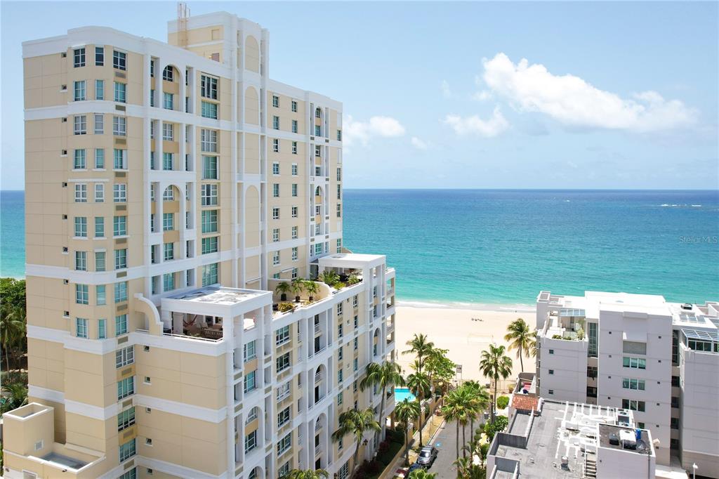 An elevated view shows a multi-story apartment building with balconies overlooking a swimming pool area — Carrion Court #6 CARRION COURT PLAYA STREET UNIT 103, SAN JUAN, PR